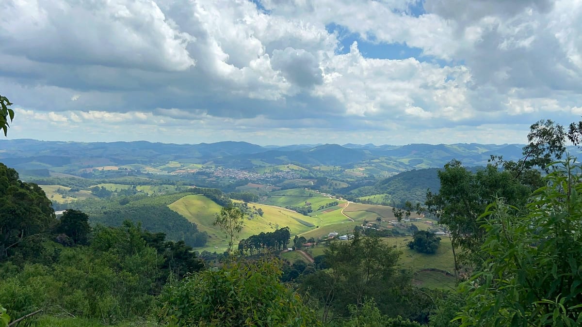 Vale e montanhas sob céu de nuvens, vistos do Alto das Pitangueiras