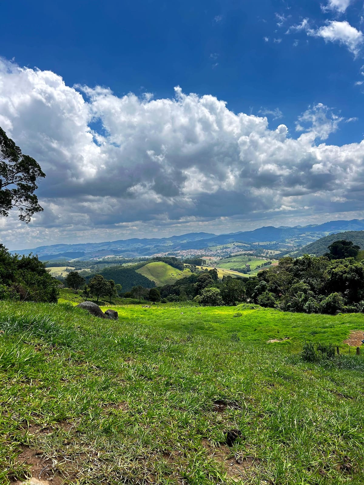 Vista vertical do vale a partir do Alto das Pitangueiras, com céu de nuvens sobre as montanhas